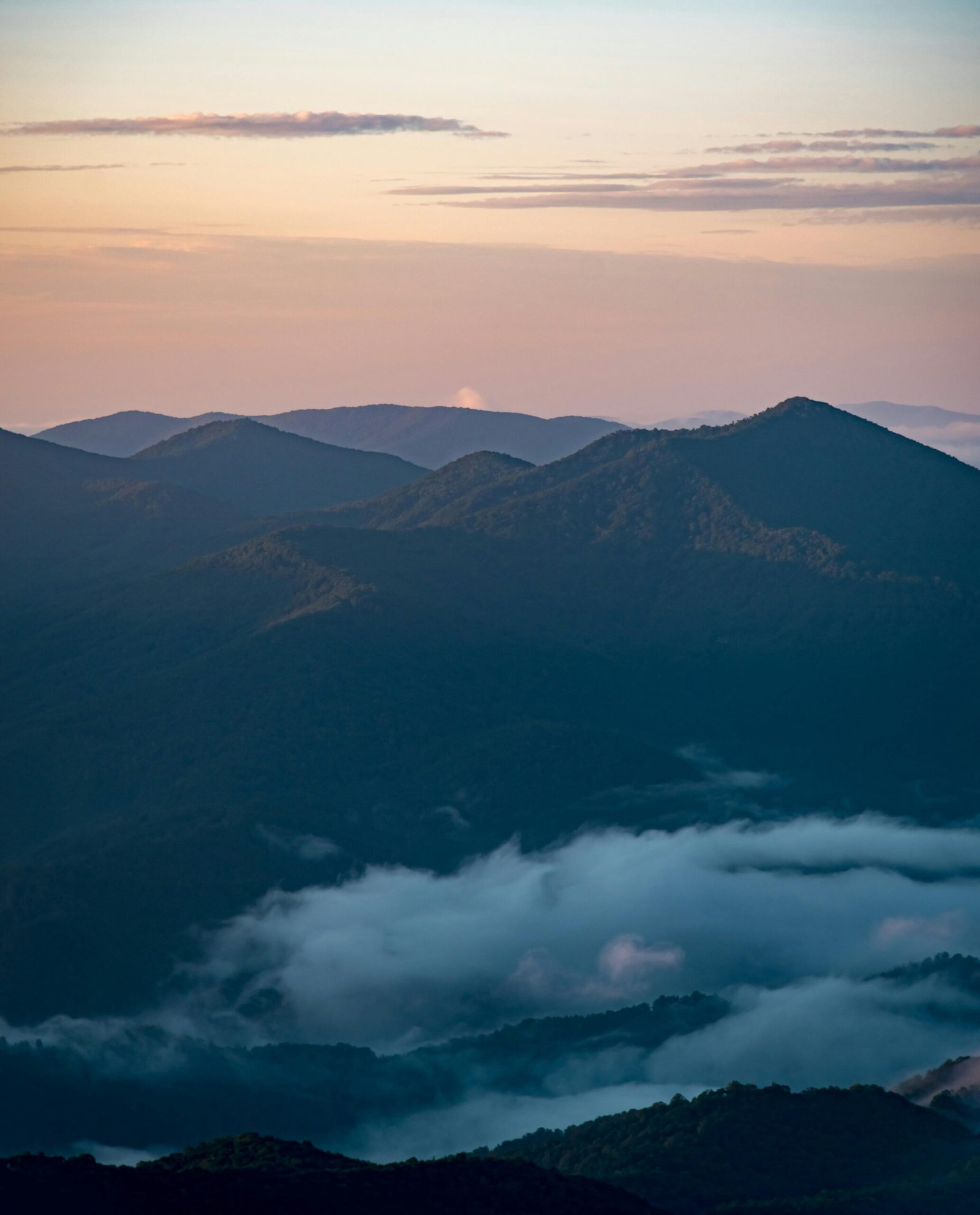 Breathtaking view of Blue Ridge Mountains with fog and twilight sky.