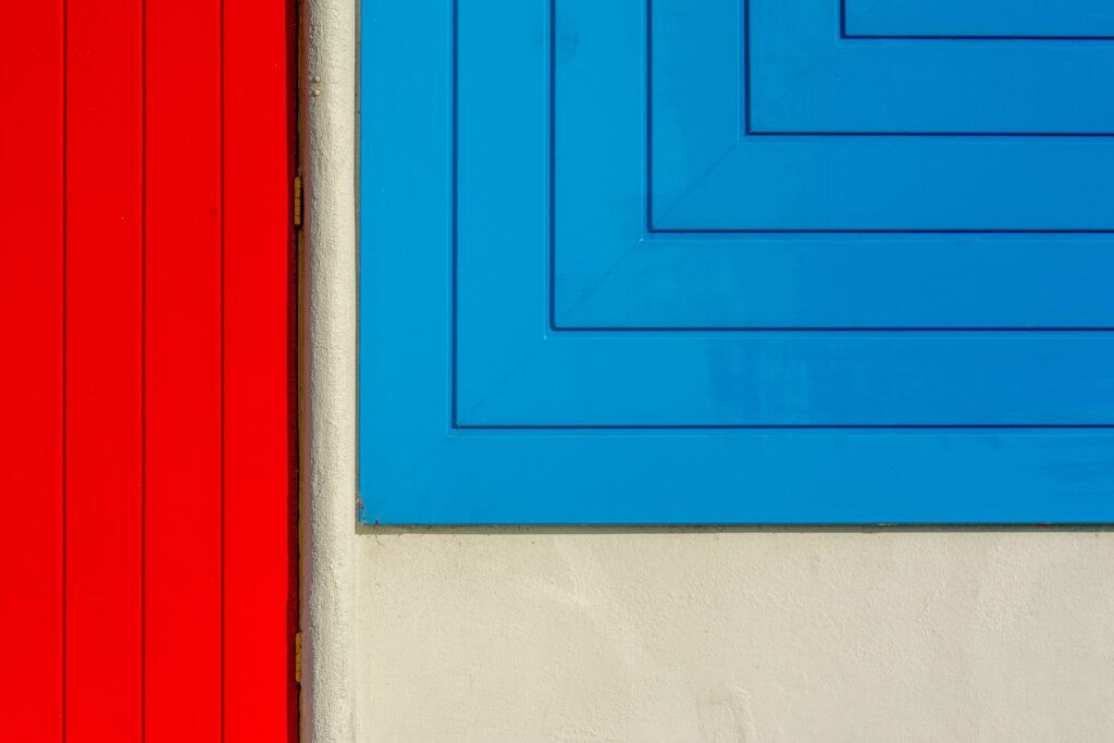 A striking abstract image featuring geometric patterns in red and blue on a building wall.